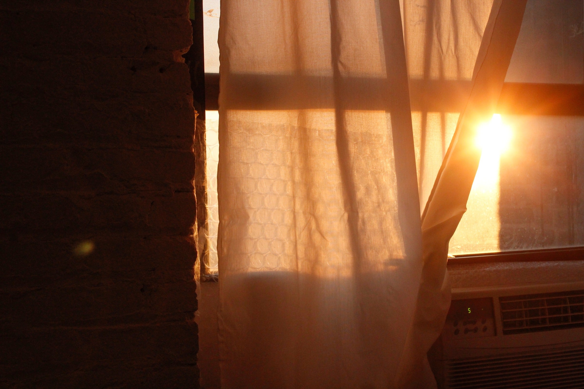 Golden evening light falling through a curtain